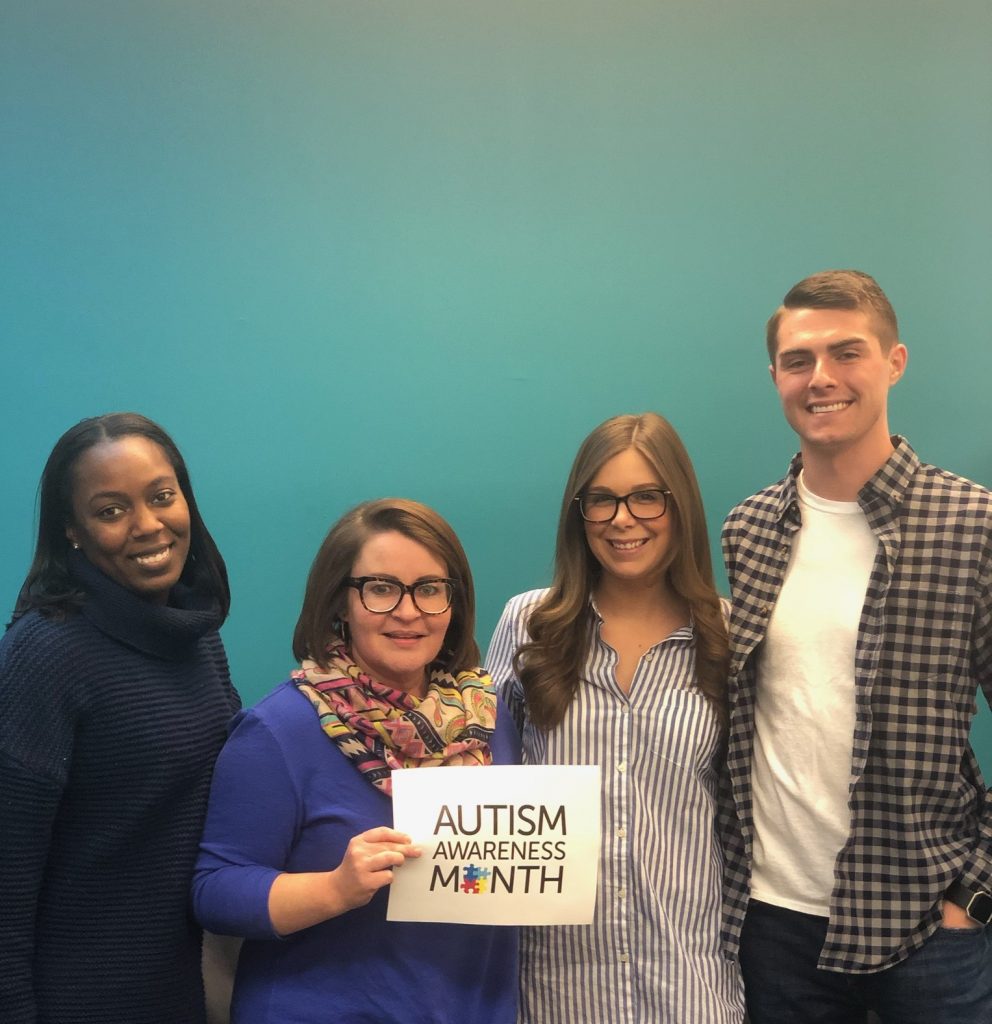 Chimes Holcomb staff hold Autism Awareness Month sign